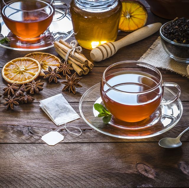 Tea time: cup of tea, cinnamon sticks, anise, dried orange on wooden table