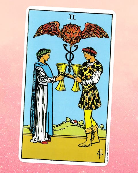 the Two Cups tarot card, showing a woman in white robes and a man in yellow page attire facing each other, holding goblets, with a winged lion above them