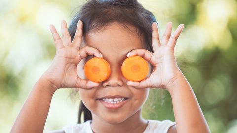 aziatisch meisje met wortelschijfjes voor haar ogen