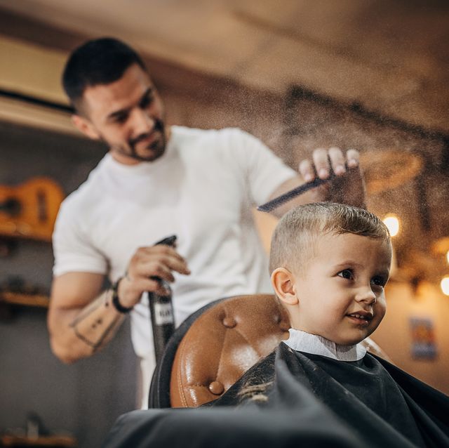 peluquero joven cortando pelo a niño