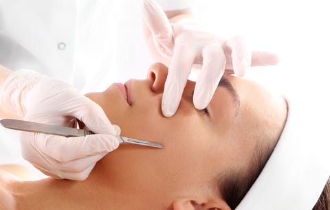 Cutting scars woman during treatment with dermatologist Cutting scars woman during treatment with dermatologist