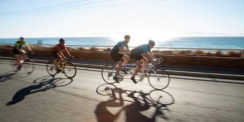 cyclists racing together at dawn in a large scale cycle event