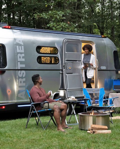 two people hanging out in front of thor airstream trailer