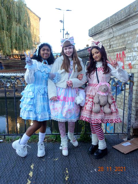 three young women in frilly dresses and sneakers