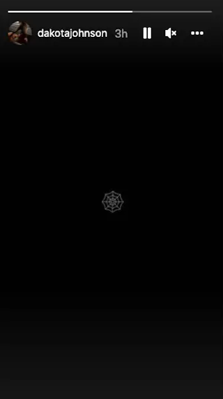 A white spiderweb emoji in the centre of the screen, against a black background