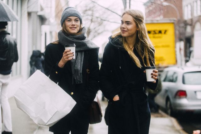 twee vrouwen lopen op straat in new york met shoptassen