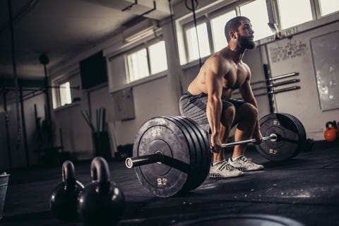bodybuilder exercising with barbells in the gym
