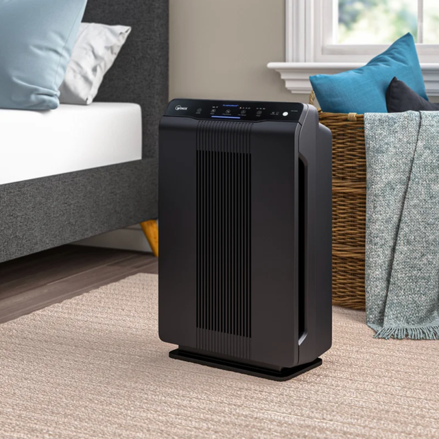 Winix Plasma Wave 5500-2 True HEPA Air Purifier a black air purifier in a bedroom scene