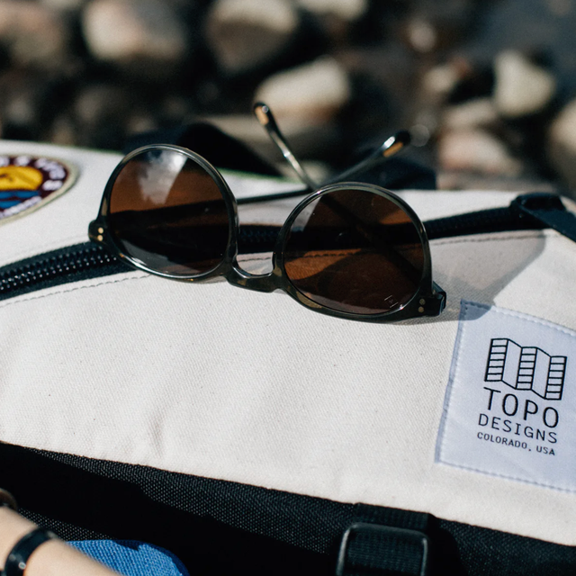 Raen x Topo Designs Remmy 52 sunglasses on a bag