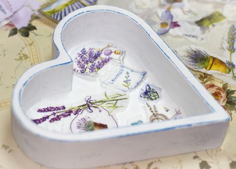 Caja blanca de madera en forma de corazón, con imágenes de lavanda en decoupage en el fondo y papel recortado alrededor