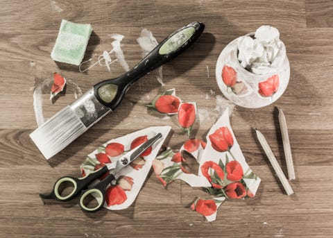 decoupage tools on wooden table, including paint brush, scissors, pencils, sponge and cut out paper