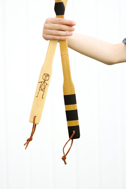 hand holding two back scratchers, one with stick figure dad on it