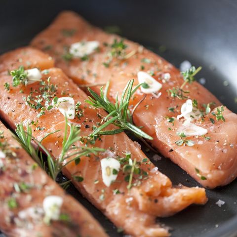 delicious salmon fillet in a pan with garlic and herbs
