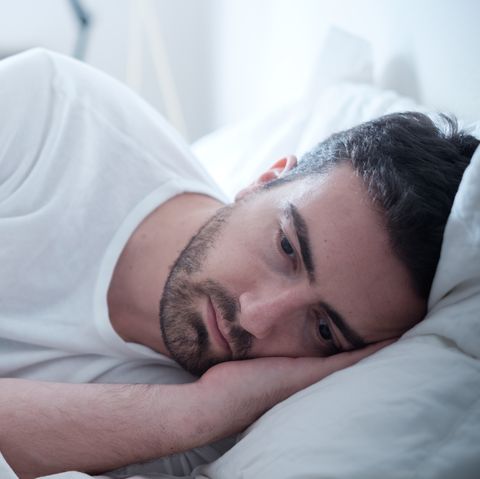 Depressed man lying in his bed and feeling bad
