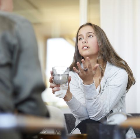 depressed teenager talking to therapist while drinking water at workshop