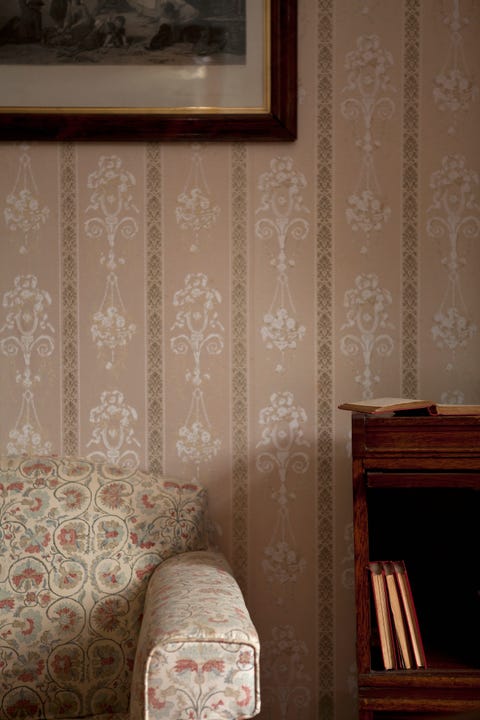 Detail of a chair and a bookshelf in an ornate living room