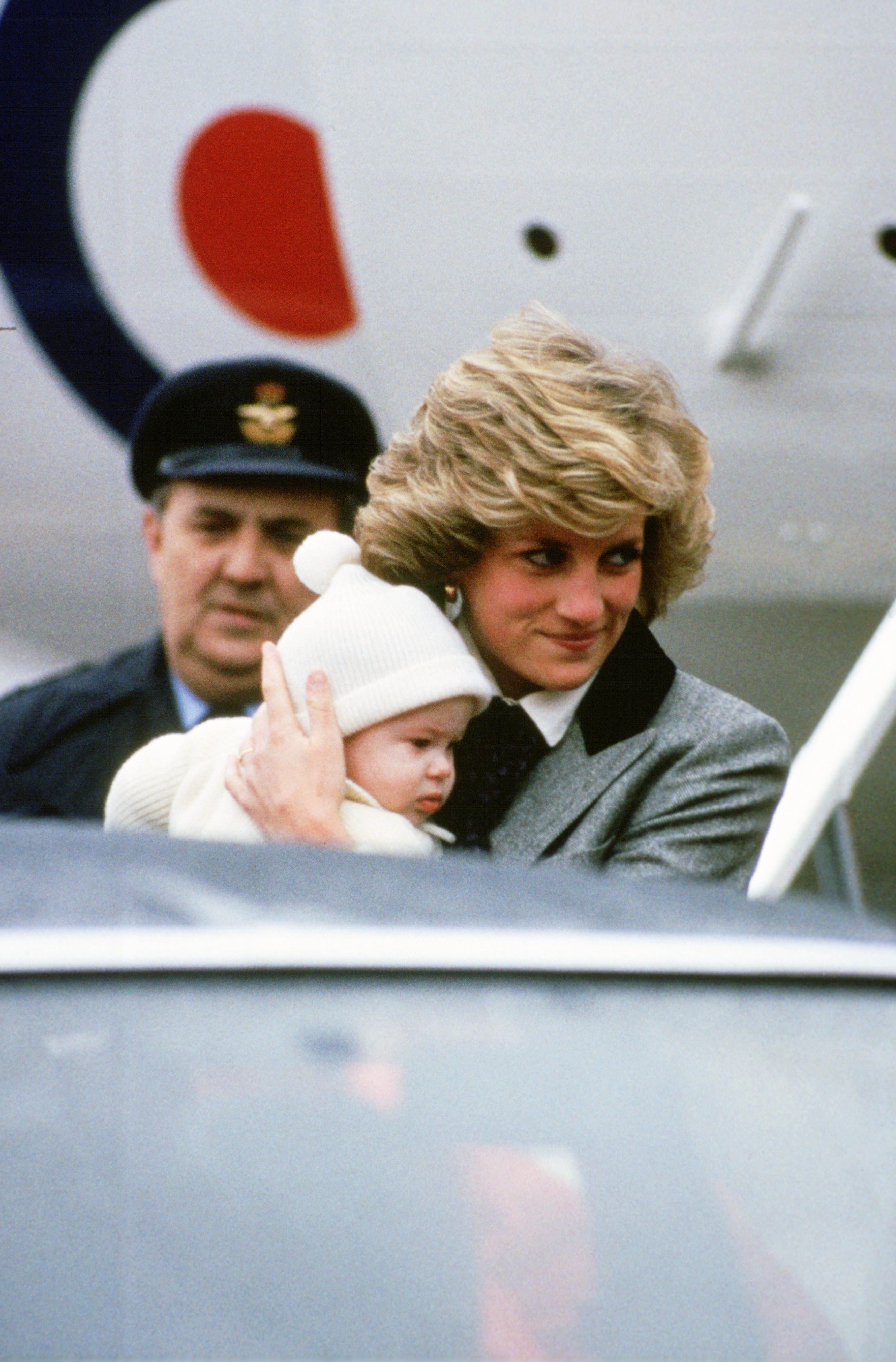 Diana, Princess of Wales carries her son, Prince Harry, off