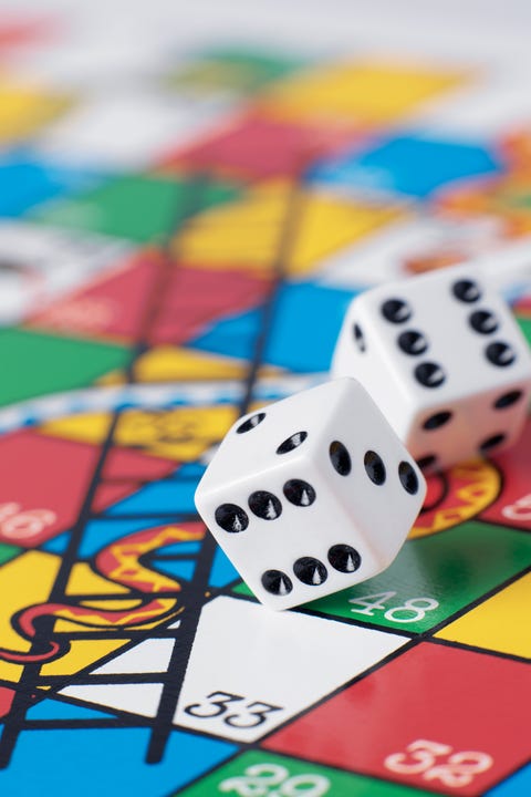 Dice falling onto snakes and ladders board dice falling onto snakes and ladders board