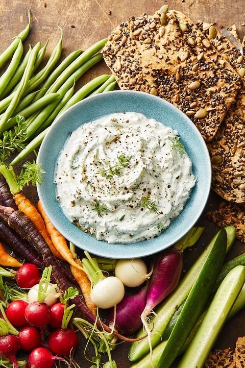 a bowl of dill dip and fresh vegetables on the side