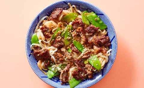 beef and noodles and snap peas in a blue bowl on a pink background from dinnerly, a good housekeeping 2022 best meal delivery service