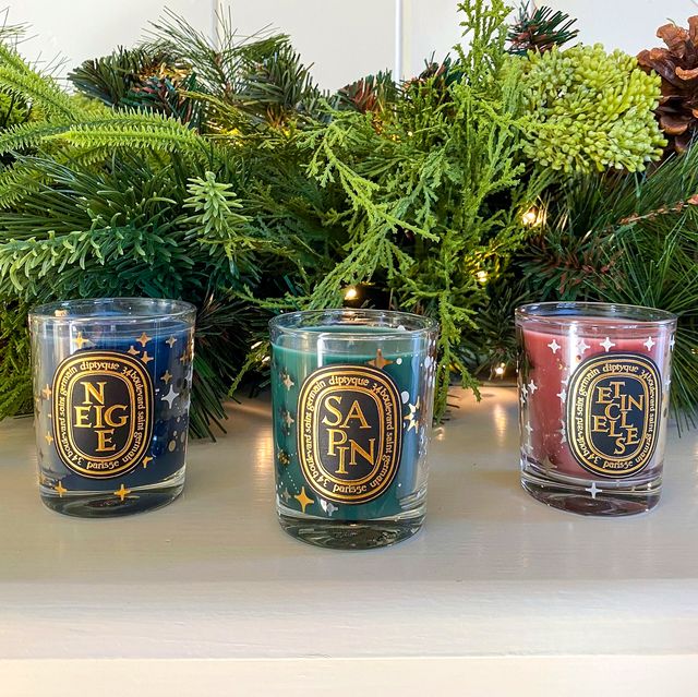 diptyque christmas candles on mantle with garland
