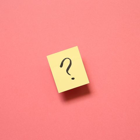 directly above shot of adhesive note with question mark against pink background