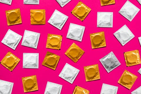 Directly Above Shot Of Condom Packets Over Pink Background