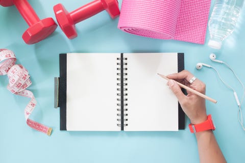 directly above shot of cropped hand writing in book on table