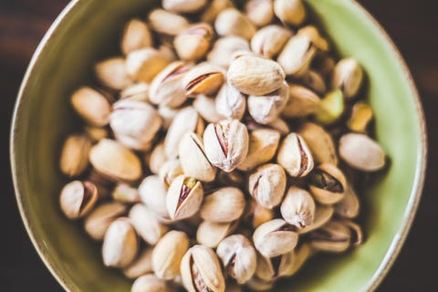 directly above shot of pistachios in green bowl