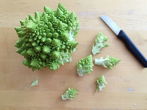 directly above shot of romanesque cauliflowers and knife on cutting board
