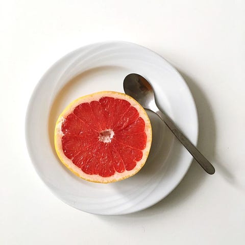 Directly Above View Of Grapefruit In Plate On White Background Directly Above View Of Grapefruit In Plate On White Background