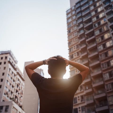 Distraught man holding his head in front of city distraught man holding his head in front of city