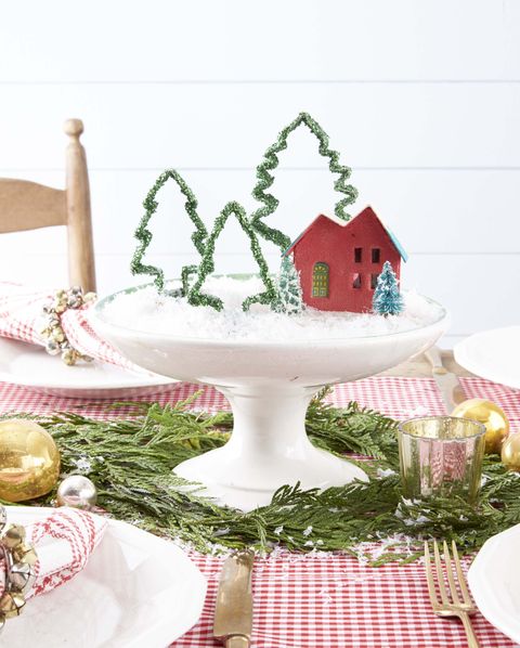 cookie cutters covered in gliter and placed in a compote that is filled with fake snow putz houses and used as a center piece