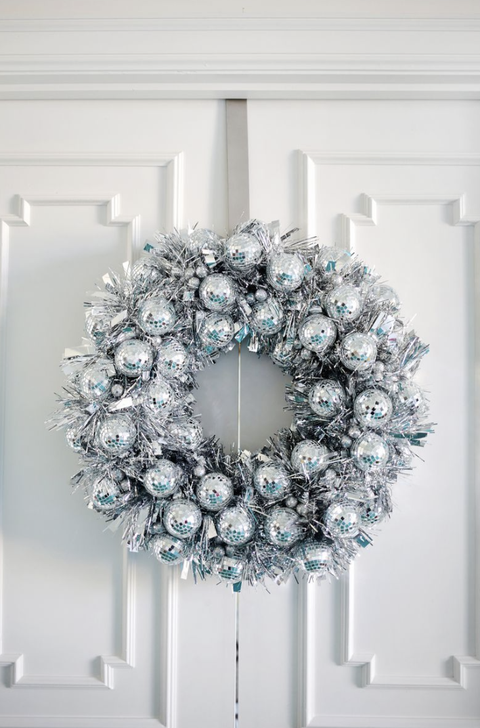 diy christmas wreaths, wreath made of disco balls hanging on a white door