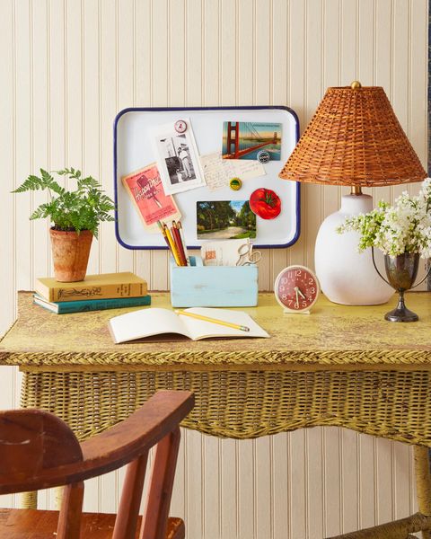 an enamelware tray used as a memo board hung above a yellow wicker desk