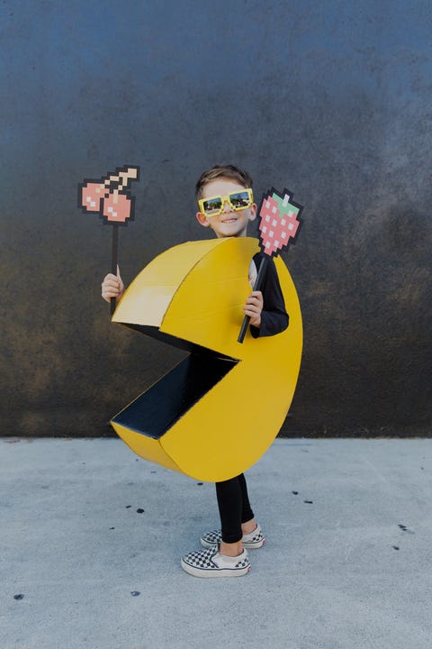 kid dressed as pac man holding fruits