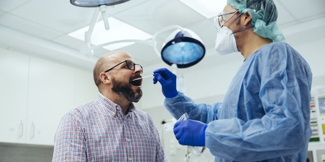 doctor in hospital taking a swab from patient's mouth