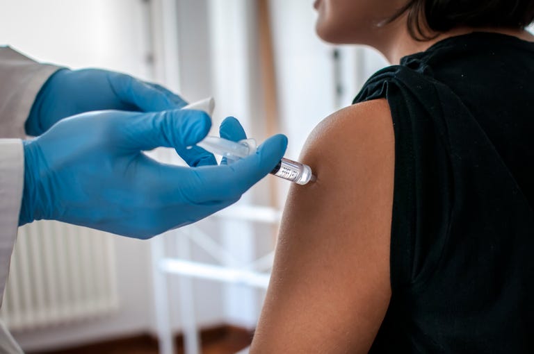 Doctor performs vaccination on a young girl