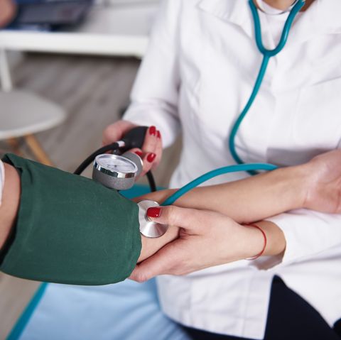 doctor taking blood pressure of woman in medical practice