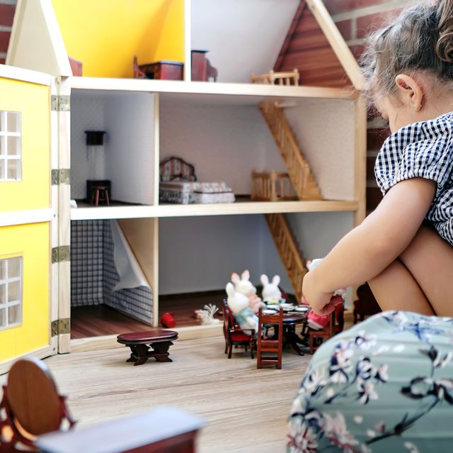 young kid playing with doll house