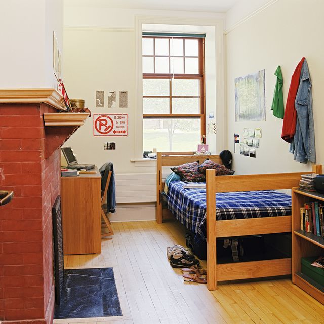 dorm room with brick fireplace and wood floor