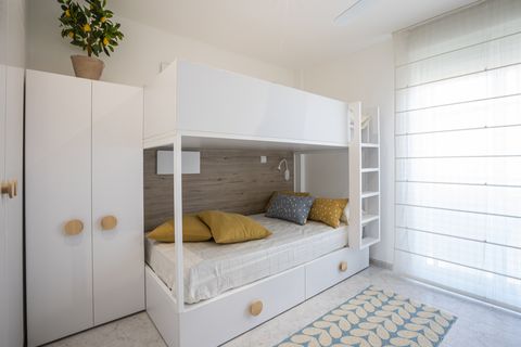 dormitorio juvenil con literas y mobiliario blanco de diseño nórdico