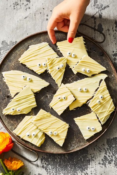 white chocolate cookie bark with candy eyes on a black plate