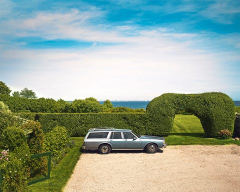 station wagon car parked in front of garden