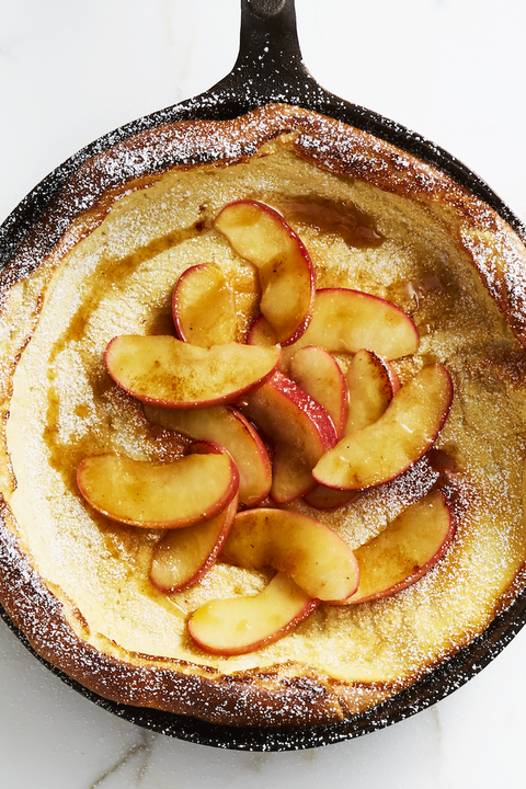 dutch baby pancake topped with peaches in  cast iron skillet