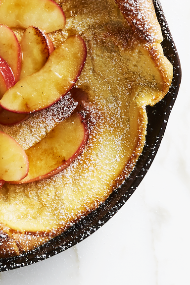 dutch baby with sliced peaches in a cast iron skillet