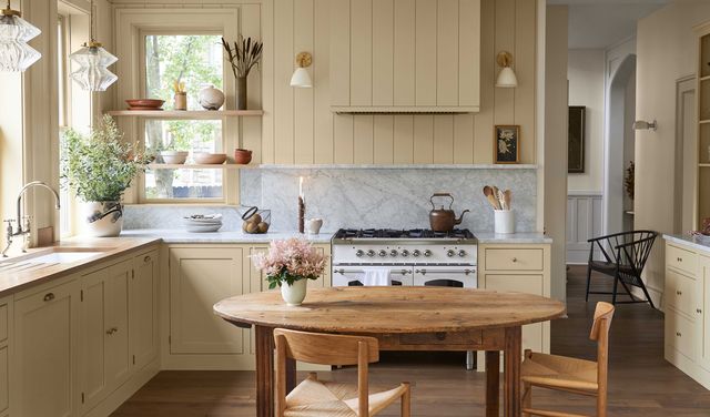 kitchen, yellow cupboard, oven, vertical panelling, wooden dining table, wooden dining chairs, gray marble countertops and backsplash
