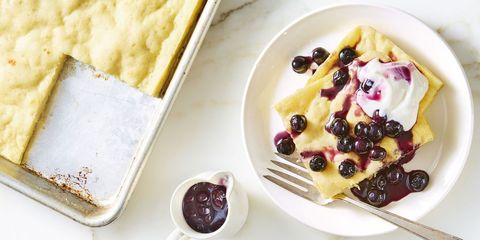 sheet pan pancake with blueberries and cream on top