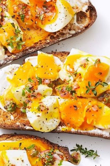 a close up of jammy egg toasts with herbs