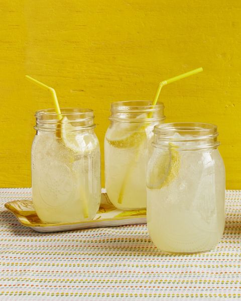 sparkling ginger lemonade in jars with straws yellow background